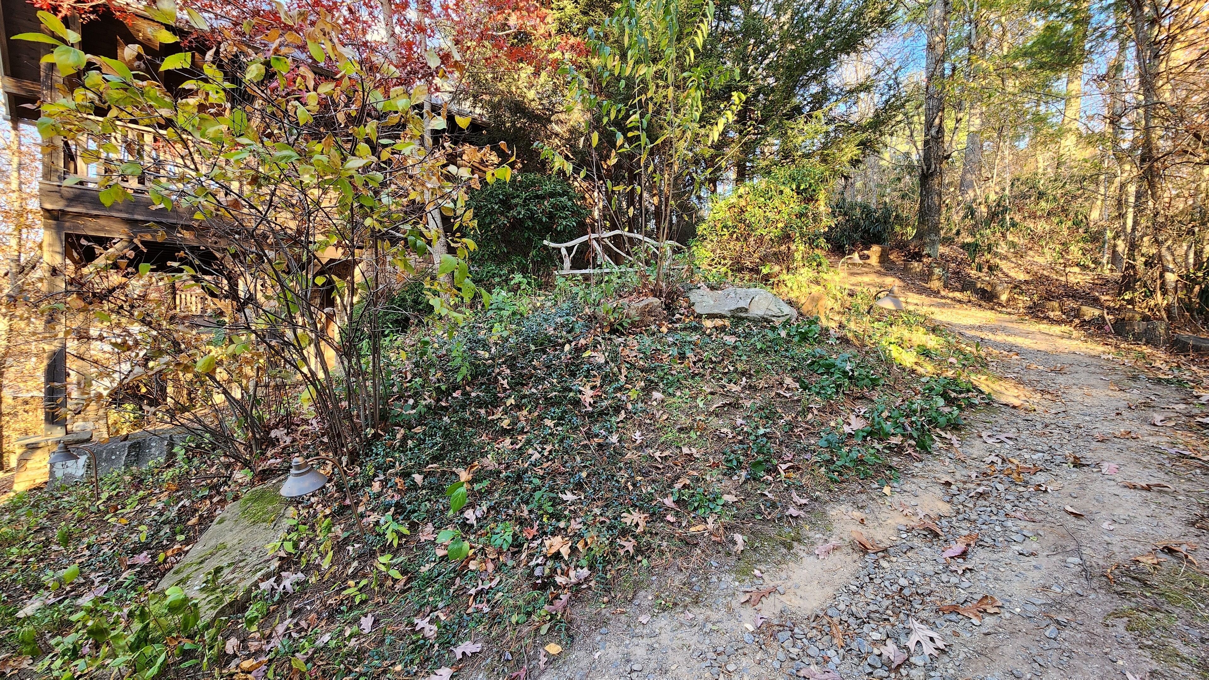 Ein naturbelassener Gartenweg mit Holzzaun und Steinmauer.