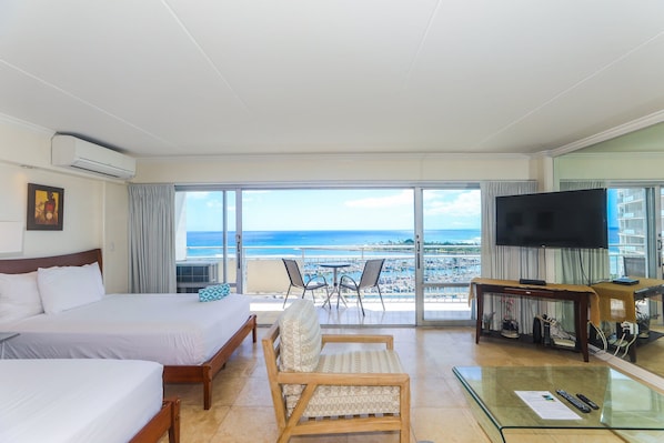 A hotel room with two beds, a TV, a glass table, and a balcony with a view of the ocean. - Ocean Breezes + Yacht Harbor Views at the Ilikai Hotel! (Honolulu)