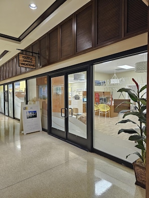A hotel interior with a reception desk, a signboard for Marina Hawaii Vacations, and a reception area with a chair and a plant. - Ocean Breezes + Yacht Harbor Views at the Ilikai Hotel! (Honolulu)