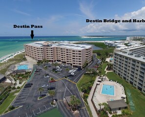 An aerial view of a hotel complex with a pool, parking lot, and a view of the ocean. - 🌊 Islander #703 – Stylish Beachfront Escape with Stunning Gulf Views 🏖️✨ (Destin)