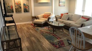 A living room with a sofa, armchairs, a coffee table, and a TV stand.