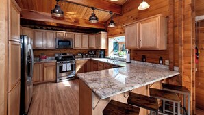 Una cocina moderna con armarios de madera, electrodomésticos de acero inoxidable y encimera de granito.
