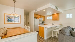A compact kitchen with wooden cabinets, a white countertop, and a built-in microwave. - 219D: Spacious Two-Level Home, Mountain Views, Fireplace, Close to Beach, BBQ - (Avalon)