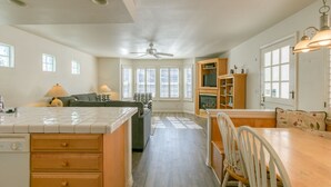 A spacious kitchen with a central island, wooden cabinets, and a dining area with a table and chairs. - 219D: Spacious Two-Level Home, Mountain Views, Fireplace, Close to Beach, BBQ - (Avalon)