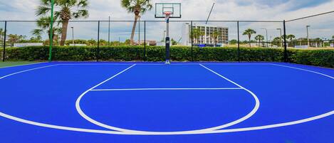 Get in a pickup game or just shoot some hoops on the vibrant blue basketball court at Phoenix III surrounded by palm trees