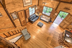 L’intérieur d’un chalet en bois comprend un espace de vie avec un canapé, une table à manger et un escalier.