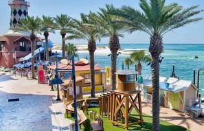 A beachside resort with palm trees, a lighthouse, and a water view. - SolMate-PoolHeat Deals-Free GolfCart,Bikes,Hot Tub (Destin)