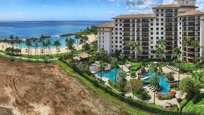Un resort con un edificio grande, playa y zona de piscina.