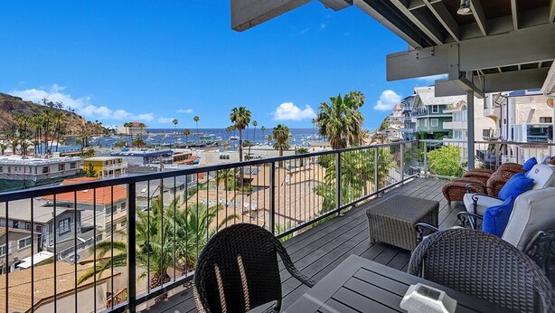 A balcony with wicker furniture, a view of the beach, and a clear blue sky. - 11LT Lower: 2BD Home with Stunning Panoramic Views,BBQ, Spacious Balcony, WIFI (Avalon)