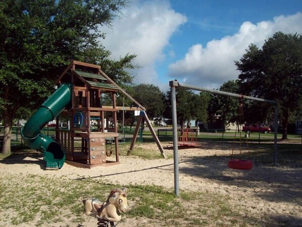 A playground with a slide, swings, and a climbing structure.
