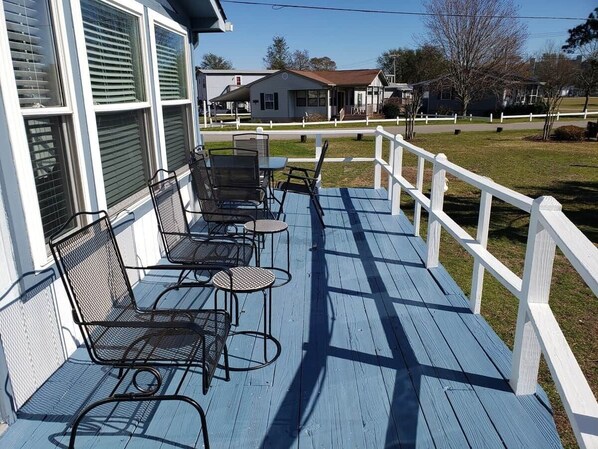 A porch with outdoor furniture and a white fence.