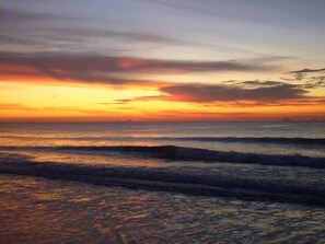 Ein Sonnenuntergang über dem Meer mit Wellen.