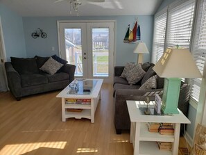 A living room with two sofas, a coffee table, a lamp, and a bookshelf.
