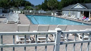 En swimmingpool med solstolar och en byggnad i bakgrunden med texten ”HICKORY POOL”.