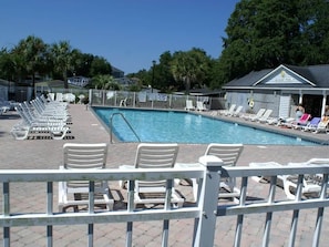 Ein Schwimmbecken mit Liegestühlen und ein Gebäude im Hintergrund, auf dem 'HICKORY POOL' steht.