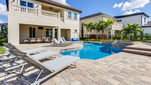 A residential property with a swimming pool, outdoor seating, and a two-story house.