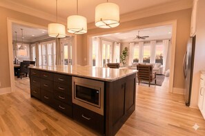 A spacious kitchen with a large island, wooden cabinets, and a built-in microwave. - Large Grand East Nash 4BR: Hot Tub (Nashville)