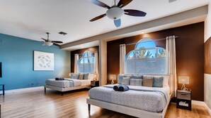 A modern bedroom with two beds, a ceiling fan, large windows, and a blue accent wall. - 5 STAR ⭐️⭐️⭐️⭐️⭐️ STUNNING PRIVATE LV ESTATE! (Las Vegas)