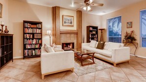 A living room with a fireplace, two sofas, a coffee table, and two bookshelves. - 5 STAR ⭐️⭐️⭐️⭐️⭐️ STUNNING PRIVATE LV ESTATE! (Las Vegas)