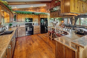 Enjoy cooking in this kitchen with an oven, refrigerator, and wooden cabinets.