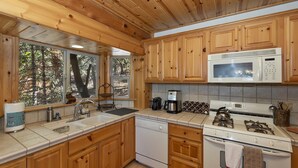 A kitchen with wooden cabinets, a microwave, a coffee maker, and a dishwasher.