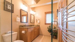 Een badkamer met toilet, wastafel en spiegel.