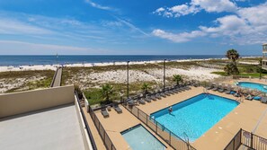 A pool area with a view of the beach and ocean.