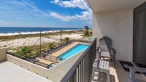 Un balcon avec vue sur une plage et une piscine.