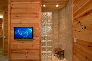 Cozy retreat with a flat-screen TV, wooden paneling, and a stylish glass partition.