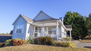 A single-story house with a front porch, a covered entryway, and a small attached garage. - Our Tennessee Mountain Home - Great Location!  Close To All The Action! (Pigeon Forge)