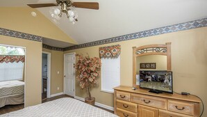 A bedroom with a bed, dresser, mirror, ceiling fan, and a potted plant. - Our Tennessee Mountain Home - Great Location!  Close To All The Action! (Pigeon Forge)