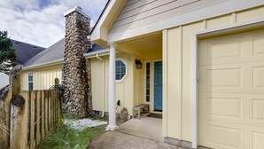 A house with a stone chimney, a covered porch, and a garage. - #119 Sunshine Shores (Pacific City)