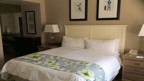 A hotel room with a bed, two bedside tables, a mirror, and framed pictures on the wall. - MARRIOTT OCEAN WATCH (Myrtle Beach)