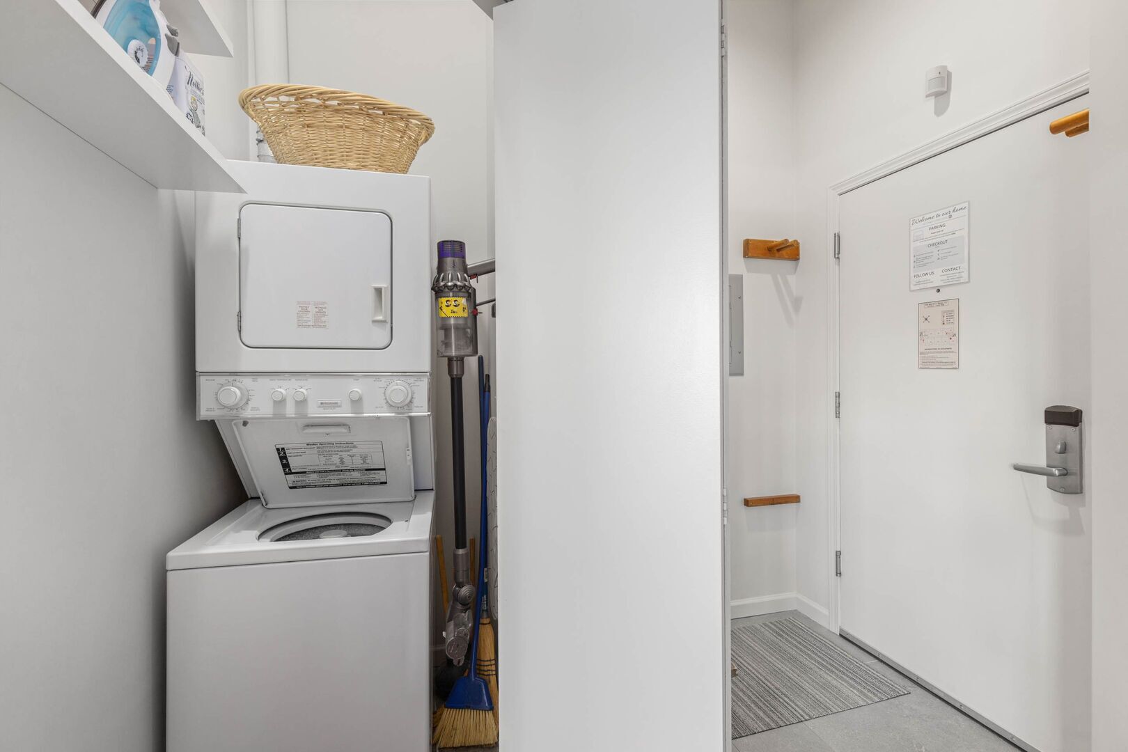 A compact laundry room with a washing machine, a drying machine, and a mop.