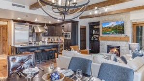 Una cocina moderna con armarios de madera oscura, electrodomésticos de acero inoxidable y una barra con taburetes.