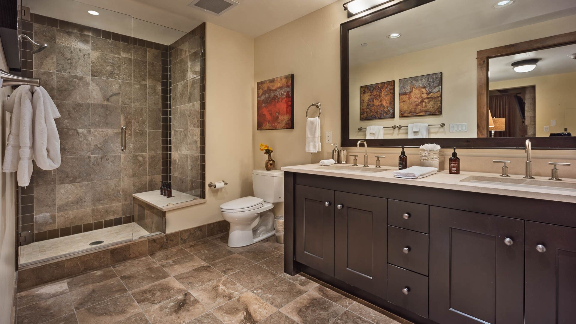 A modern bathroom with a shower, toilet, and vanity.