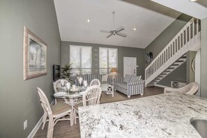 Relax in this spacious living area with a high ceiling, dining table, and comfortable sofa.