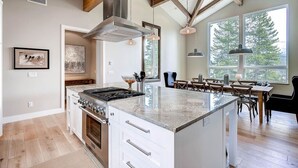 A modern kitchen with a large island, wooden beams, and large windows. - Sunrise Ski Haus: Peak 8 Breckenridge Home with Hot Tub and Views, Near Slopes (Breckenridge)