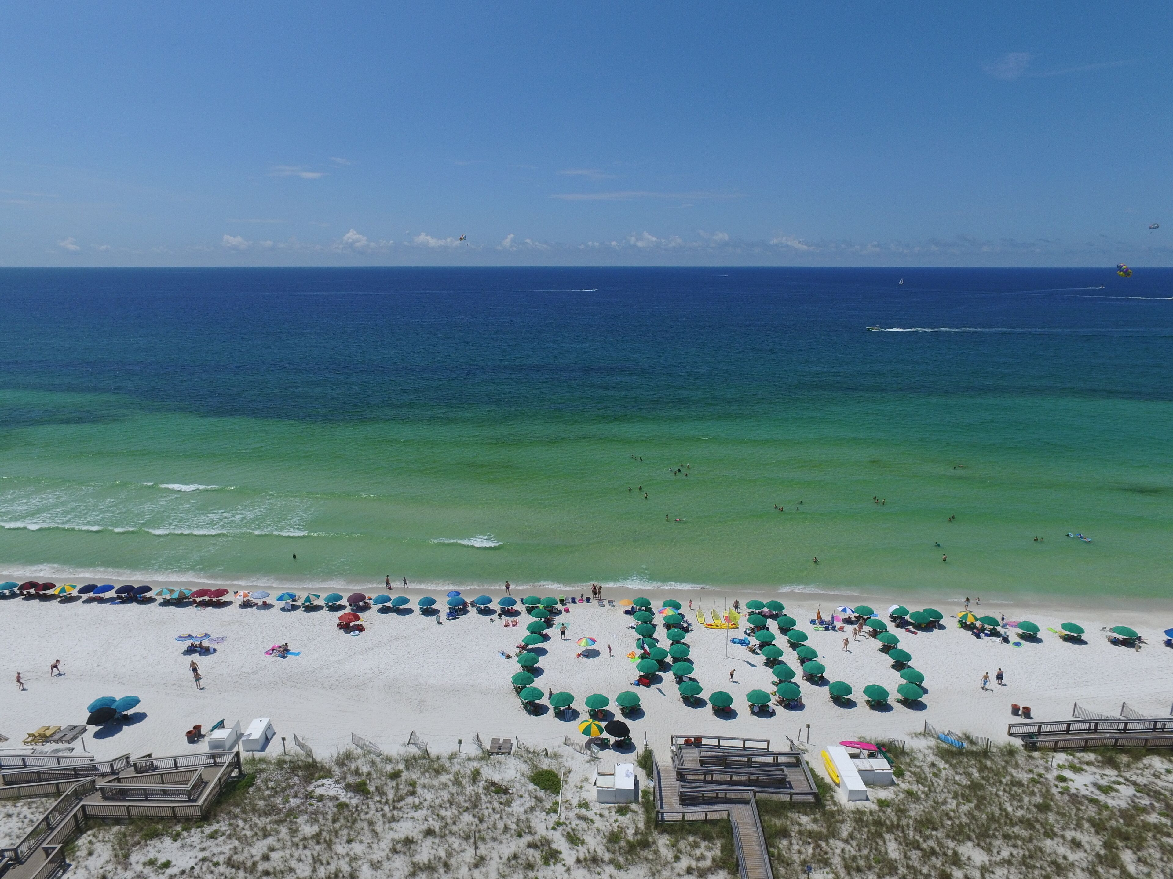 A beach with umbrellas and people.