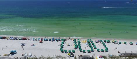 A beach with umbrellas and people.