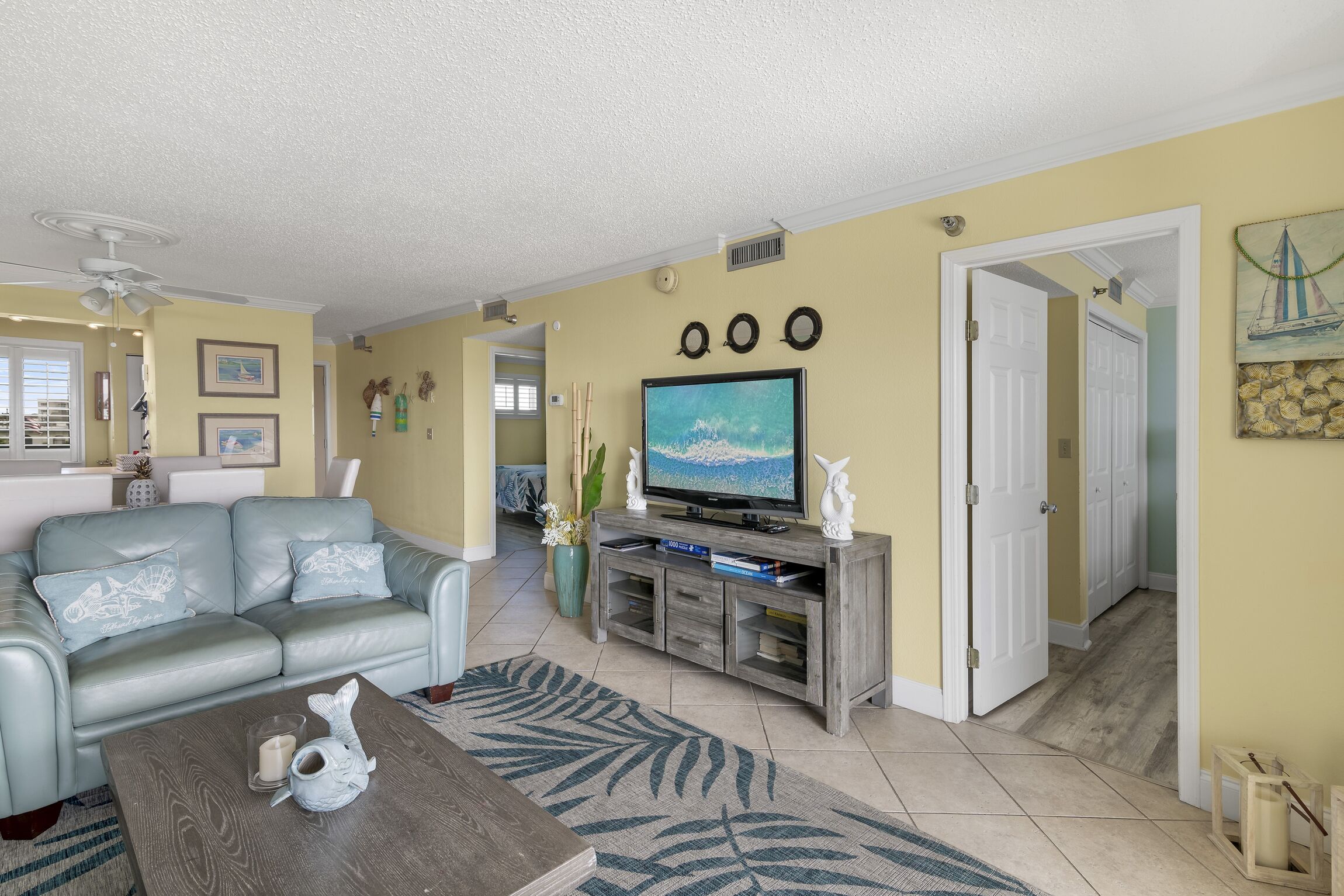A living room with a sofa, coffee table, TV, and decorative items.