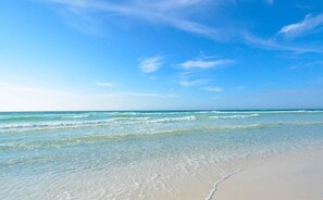 Ein Strand mit klarem, blauem Wasser und einem Sandufer.