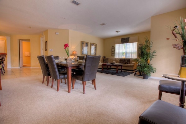 A living room with a dining area, a sofa, and a coffee table.