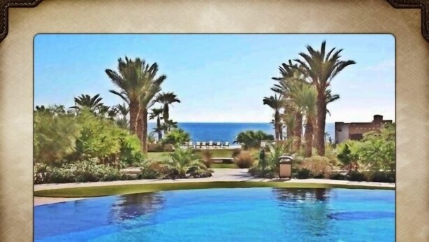 Ein Resort mit Swimmingpool, Palmen und Blick aufs Meer.