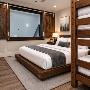 A modern bedroom with a large bed, wooden headboard, and a view through a window.