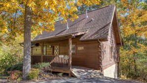 A wooden cabin with a porch, a chimney, and a sign indicating it is a museum. - ER 23 – Smoky Memories  Great Location – Close to town! (Pigeon Forge)