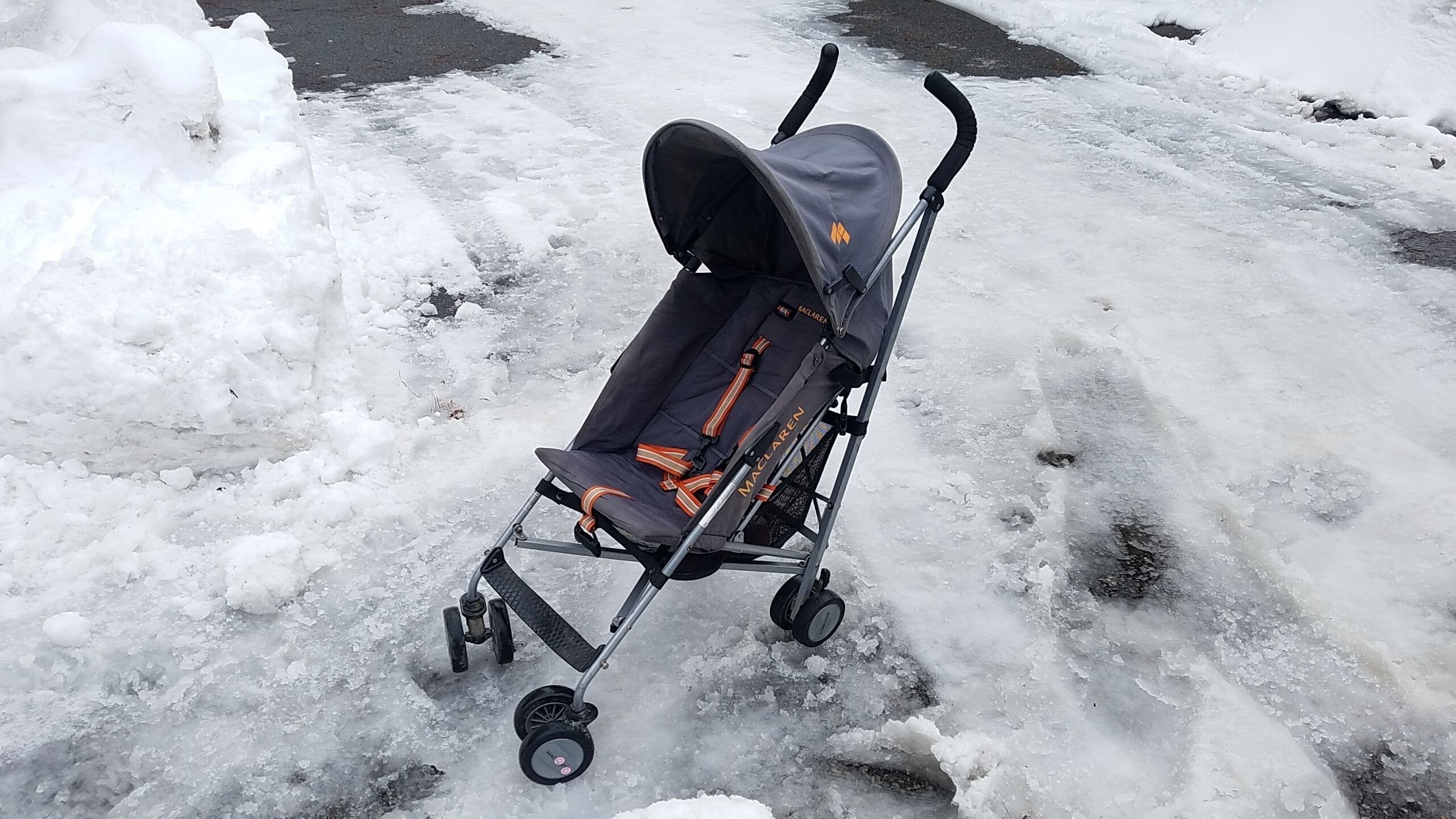 A stroller on a snowy surface.