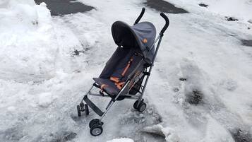 A stroller on a snowy surface.