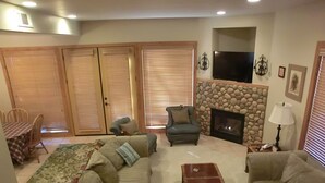 A living room with a sofa set, a coffee table, a fireplace, and a television.