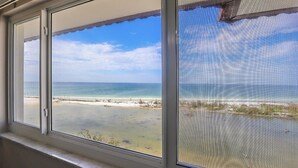 A window with a view of a beach and ocean. - Sand Caper Beachfront Condo With Spectacular 7th Floor View of the Gulf! (Ft. Myers Beach)